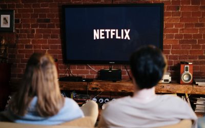 Netflix, man and woman sitting on a couch in front of a television