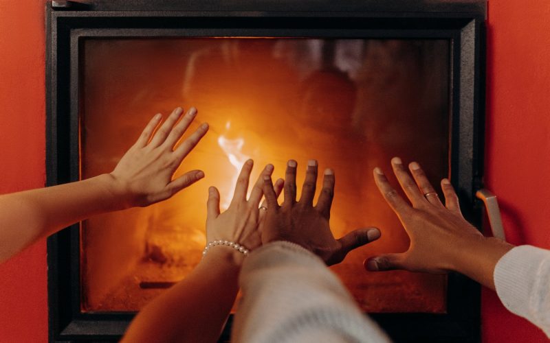couples hands by fireplace